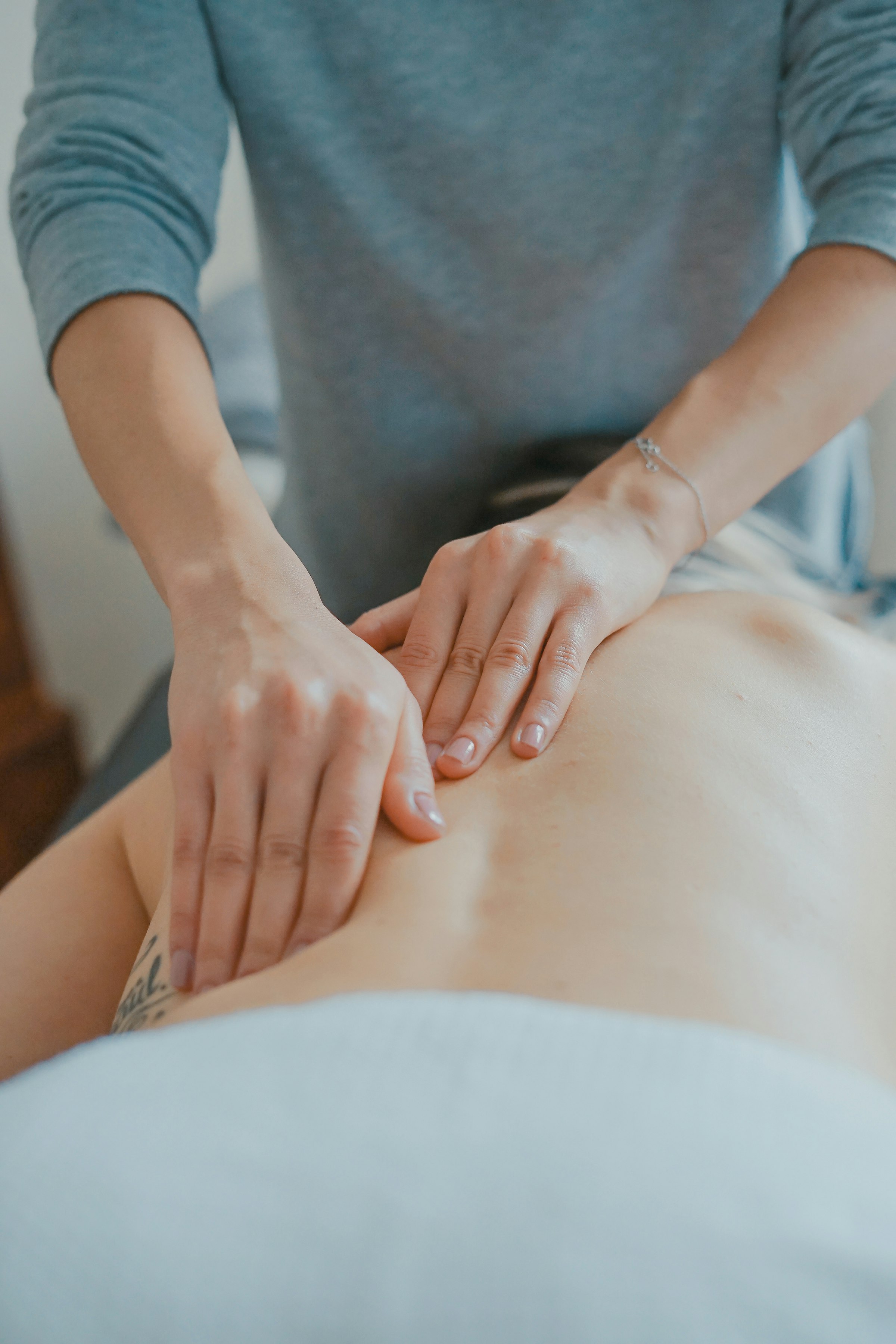 Therapeutic bodywork — a practitioner's hands working with a client